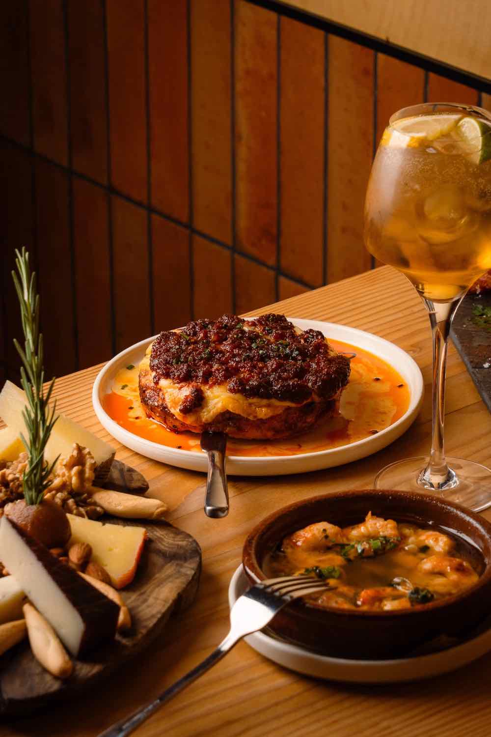 A plated Spanish dish with a glass of wine at Piggs