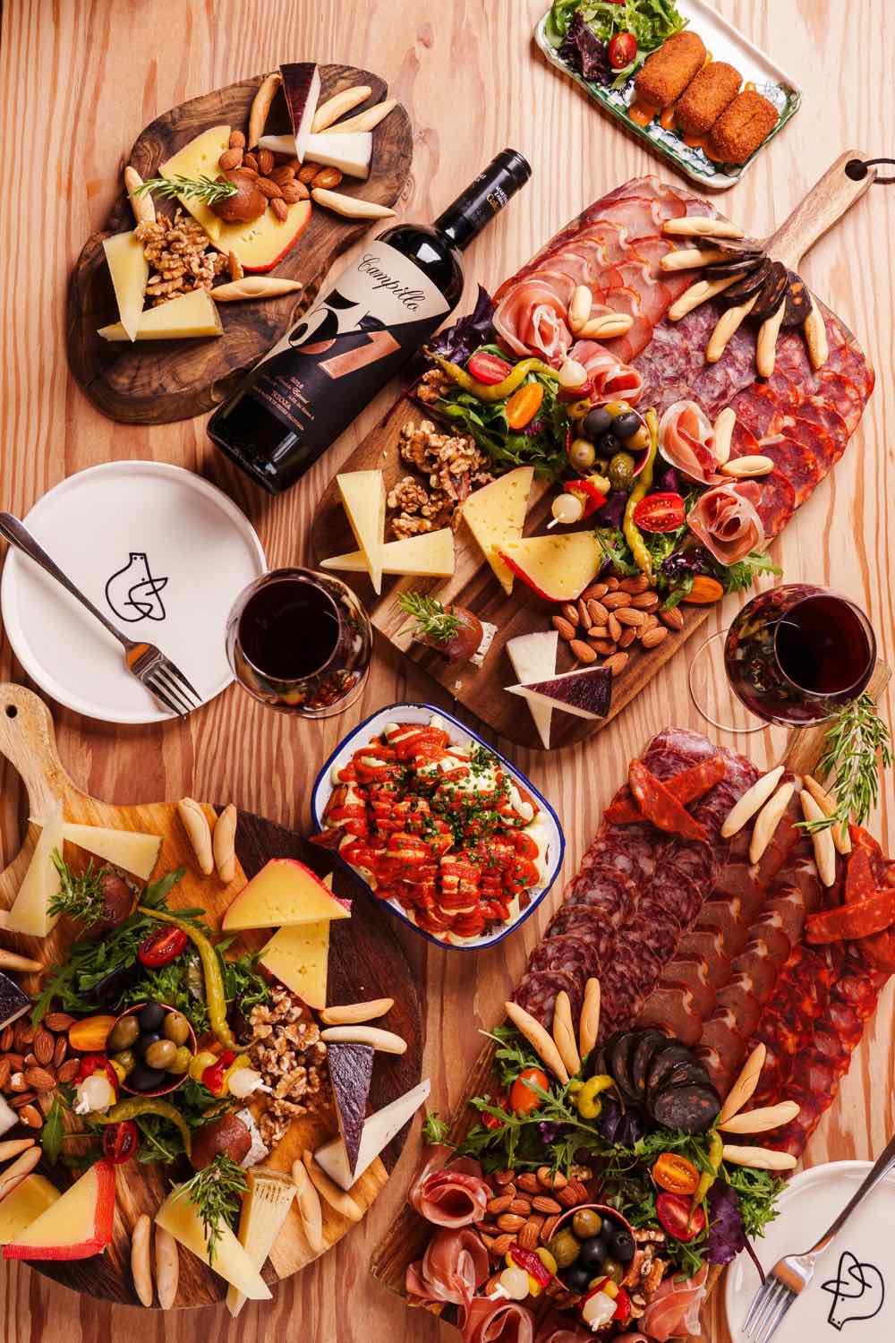 An overhead spread of tapas boards, plates and wine at Piggs