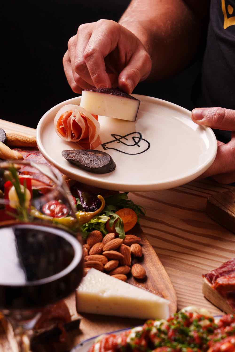 Hands plating a dish with cheese on a Piggs enamel plate